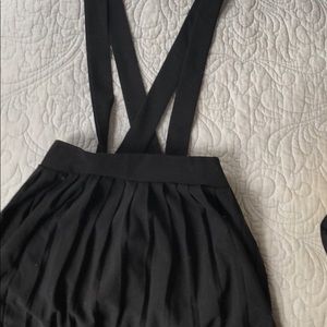 Black overall dress with pleated skirt
